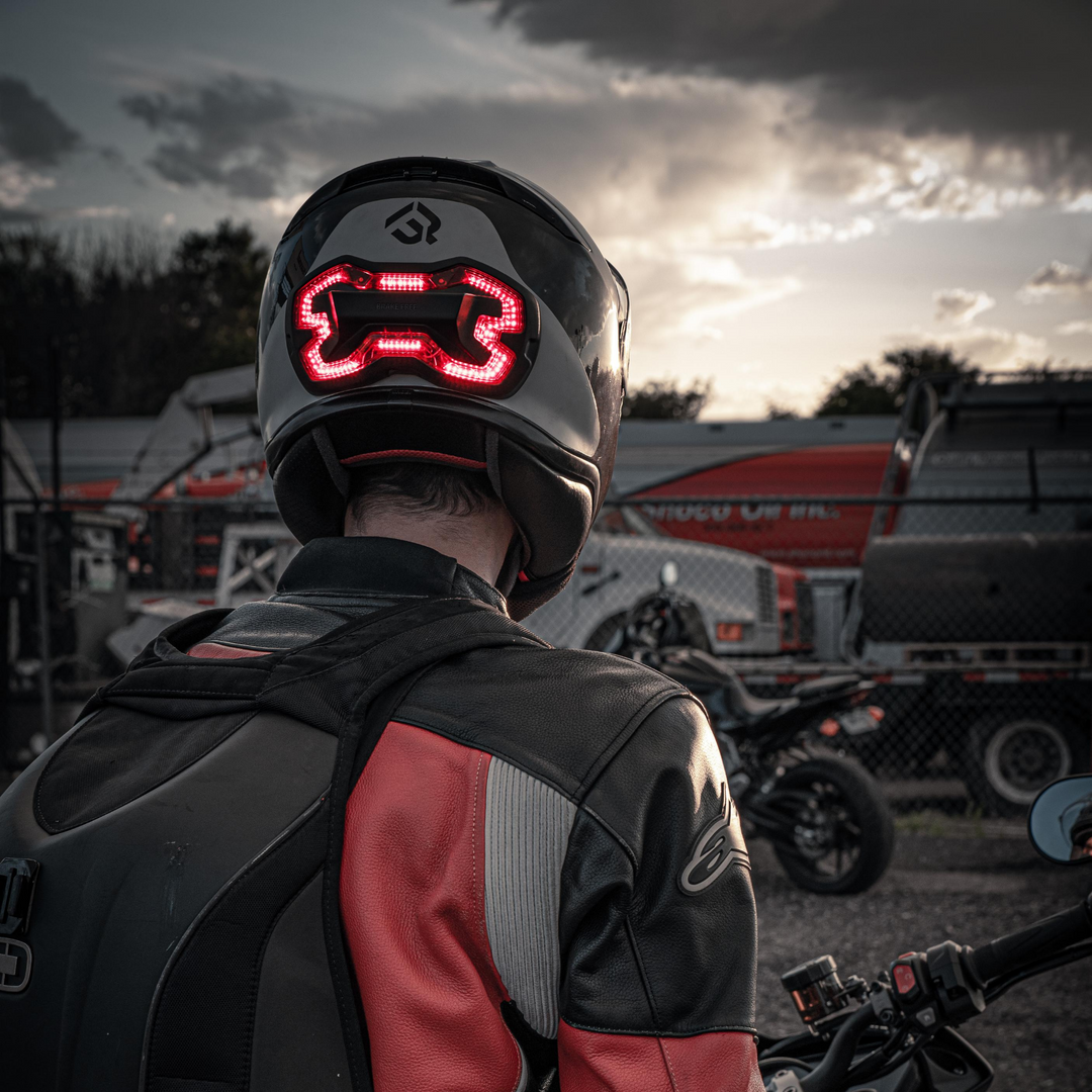 Lifestyle photo of black Brake Free. Brake Free is an ultra-bright smart LED brake light that instantly improves rider's visibility. Simple installation, no wires. Smart brake light for your helmet. Be seen day and night. Ride in any weather. Long lasting rechargeable lithium ion battery.